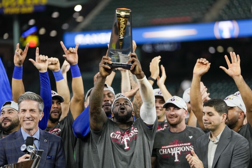 Adolis Garcia holding a trophy in front of a crowd