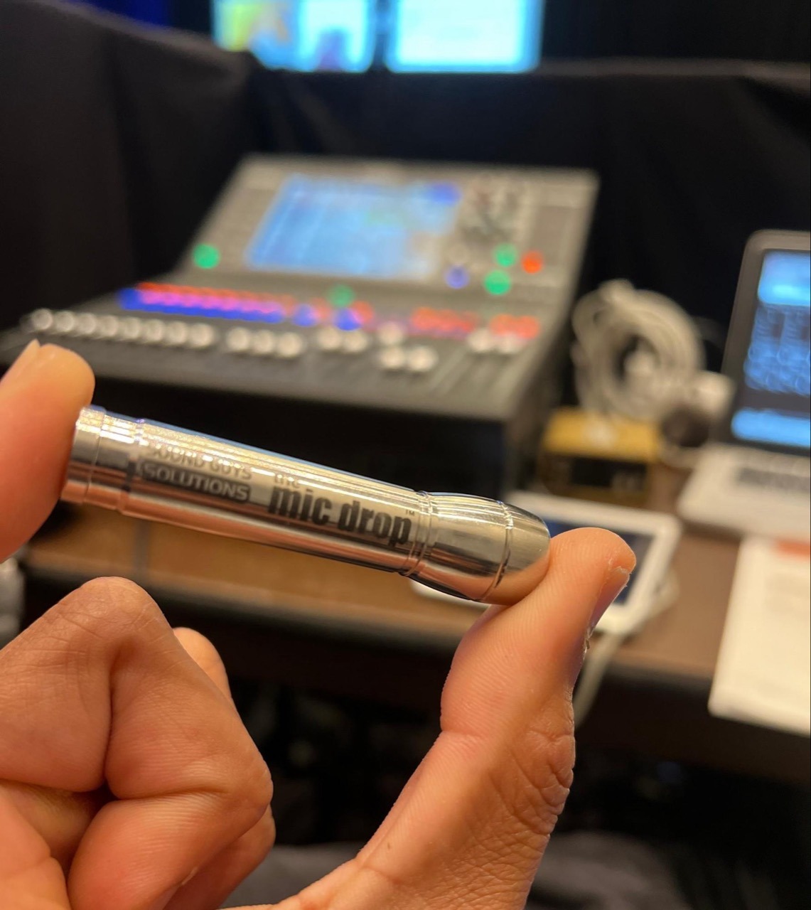 a person holding a lav mic drop in their hand